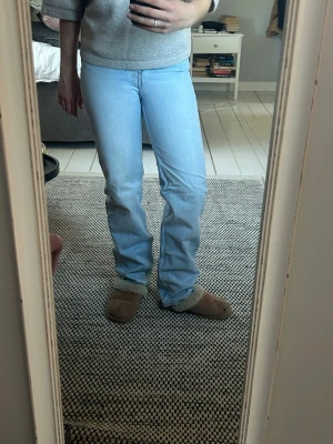 Ljusblå bootcut jeans - Säljer ett par ljusblå raka jeans från weekday  med klassisk femficksdesign och normal midja. Framtill är midjan snedskuren vilken ger en superfin form. Jeansen har en avslappnad passform över låren och lätt utsvängda ben. Perfekta för en casual look och passar till det mesta i garderoben. Favoriter som tyvärr blivit för små.