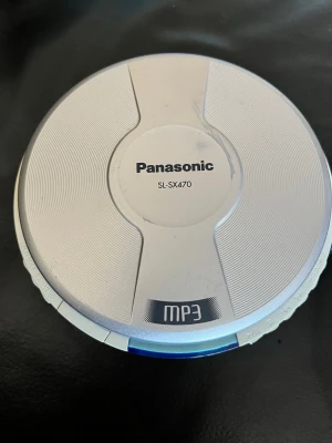 Panasonic SL-SX470 bärbar CD-spelare - Säljer en silverfärgad bärbar CD-spelare från Panasonic, modell SL-SX470. Spelaren har en rund form, tydlig LCD-display och stöd för MP3-skivor. Perfekt för dig som gillar retroprylar och vill lyssna på musik på språng.