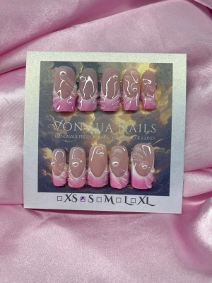 BabyGloss (S);Medium Square - Handgjorda press-on naglar i storlek S: 15 mm, 11,5 mm, 12 mm, 11 mm, 9 mm . Naglarna har en nude bas med rosa fade tippar och abstrakta handmålade 3Dnailart linjer samt små pärldetaljer. Formen är medium långa squsreform. Perfekt för dig som vill ha en unik och trendig look.
