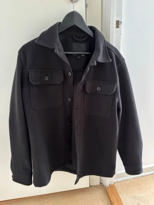 Svart overshirt med fickor  - Stilren svart overshirt från lager 157. Säljer då den ej används. Kan gå ner i pris vid snabbt köp. Knappt använt 