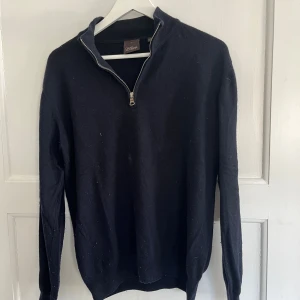 Mörkblå halvzip-tröja från Oscar Jacobson - Stickad Mörkblå halfzip-kashmirtröja från Oscar Jacobson i storlek M. En liten fläck som syns på bild annars är den i acceptabelt skick. Vid övriga frågor är det bara att skriva mvh Ludvig