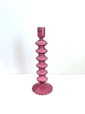 Lila glasljusstake med vågig form - Säljer en snygg ljusstake i lila glas med vågig, räfflad design och bred fot. Perfekt som dekoration på bordet eller i fönstret. Ljusstaken har en modern look och är tillverkad i genomskinligt glas.