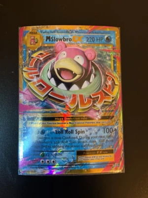 Pokémonkort M Slowbro EX holo - Säljer ett färgstarkt och glansigt Pokémonkort, M Slowbro EX med 220 HP. Kortet har holografisk yta med rosa, blå och gula detaljer samt japansk text. Perfekt för samlare eller dig som vill boosta din lek med en mega-evolution.