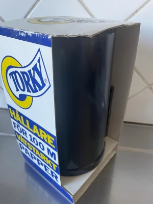 Torky hållare svart plast - Praktisk hållare från Torky i svart plast för 100 meter våtstarkt papper. Perfekt för kök eller verkstad där du behöver enkel tillgång till hushållspapper. Kommer i originalförpackning.