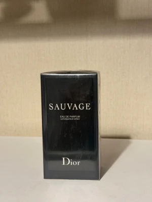 Dior Sauvage Eau de Parfum 100ml - Dior Sauvage Eau de Parfum i 100 ml flaska. Parfymen kommer i en elegant, mörkblå nästan svart rektangulär förpackning med tydlig Dior-logga. En klassisk och populär doft som passar perfekt för dig som vill ha något tidlöst.