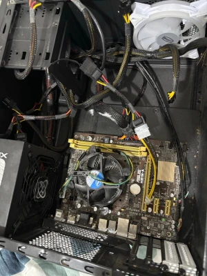 ASUS moderkort med Intel-processor - Stationär dator med ASUS-moderkort, Intel-processor med kylare, flera RAM-platser och nätaggregat. Svart chassi med synliga kablar och en vit fläkt för kylning. Perfekt för dig som vill bygga eller uppgradera din egen dator.