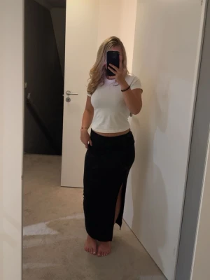 Svart långkjol med slits - Jätte fin svart tajt kjol med en split på höger sida. Kjolen passar mig jätte bra som är 160😍😍