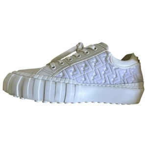 Vita sneakers från Fendi - Äkta  vita sneakers från Fendi med ett unikt mönster på sidan och en chunky sula. Skorna har snörning och är tillverkade i ett stilrent syntetmaterial. Perfekta för att ge din outfit en lyxig touch. 