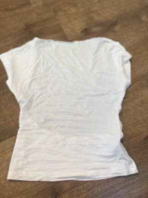 Vit topp från SHEIN - En enkel och stilren vit topp från SHEIN i storlek XS. Toppen har korta ärmar och är gjord i ett mjukt material som känns skönt mot huden. Perfekt att matcha med jeans eller kjol för en clean look. Tröjan har ingen rygg där bak så de en rygglös thsirt vilket är perfekt till sommaren då det blir varmt 