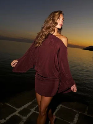 Vinröd offshoulder kortklänning - Säljer en vinröd kortklänning med offshoulder-design och vida, fladdriga ärmar. Klänningen har en loose passform och är tillverkad i ett mjukt, lätt material som ger en avslappnad men ändå snygg look. Klänningen är helt oanvänd med prislapp kvar.!!