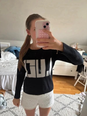 Svart tröja med vit text  - Snygg svart tröja med stor vit text framtill i grafisk stil där det står ”LUCK”. Tröjan har rund halsringning och långa ärmar. Perfekt för dig som gillar en enkel men trendig look. Finns inget märke på tröjan eller en storlek, skulle däremot säga att det är runt xs/xxs något sånt! men om ni vill ha fler bilder på plagget kan ni få det. 