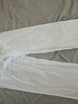 Vita linnebyxor från Gina Tricot - Säljer ett par vita linnebyxor från Gina Tricot med avslappnad passform och resår i midjan. Byxorna är tillverkade i ett lätt och luftigt linnematerial, perfekta för varma dagar. Klassisk rak modell som är enkel att matcha med olika stilarter. Är endast använd en gång 🫶