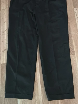 Svarta kostymbyxor från Lloyd's - Stilrena svarta kostymbyxor från Lloyd's Club Collection. Byxorna har raka ben, uppvikta benslut och bälteshällor i midjan. Klassisk design som passar till skjorta eller kavaj. Materialet känns slätt och elegant.