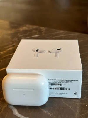 Apple AirPods Pro med MagSafe-laddning - Säljer ett par vita Apple AirPods Pro med MagSafe-laddningsetui. Modellnamn och nummer syns på bilden från telefonen. De funkar bra, men ena hörluren krasslar lite ibland (främst vid användning av brusreducering). Men jag har använt dem mycket utan problem länge. Har fått nya AirPods i present, därav säljer jag dessa. Originalförpackning inklusive obruten laddningskabel medföljer.  Hör av er vid frågor.   Med vänliga hälsningar, Simelle