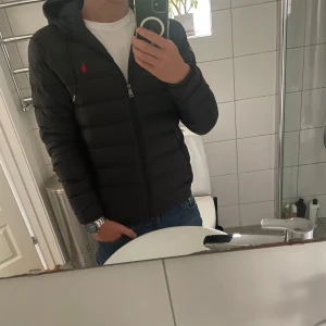 Svart dunjacka Polo Ralph Lauren  - Säljer denna riktigt snygga jackan från Ralph Lauren. Säljer den då jag har köpt en annan. Storlek S som passar 175cm perfekt. Cond: 9/10. Inga defekter och endast använd under förra vintern. Säljer den för 2299kr, priset kan diskuteras. nypris: 3499kr. 