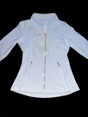 Vit/guld define jacket med dragkedjor lululemon - Snygg vit + guld define jacket , exakt likadan som lululemon med figurnära passform. Jackan har hel dragkedja framtill, två fickor med dragkedja och hög krage. Tillverkad i ett lätt och stretchigt material som passar perfekt för blåsiga dagar.