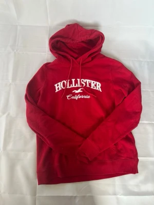 Röd Hollister hoodie - En riktigt fet hollister tröja! Sitter M me. Lite stort och har fint skick. | Skick:9/10 | modellen är cm lång‼️ Mått armhåla-armhåla 52cm och armhåla-slut 40cm. Pris 499 men kan diskuteras😁☺️🤩