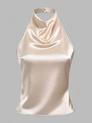 Champagnefärgad halterneck topp i satin - Fest topp. Snygg champagnefärgad halterneck topp i satin med draperad front och smal knäppning i nacken. Toppen har dekorativa knytband i ryggen som ger en extra detalj. Perfekt för dig som vill ha en elegant och trendig look. 