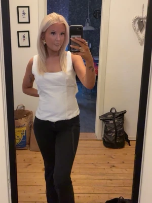 Vit linnetopp med rosett i ryggen - Säljer en stilren vit linnetopp med rosett i ryggen