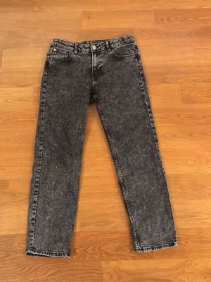 Svarta jeans, relaxed fit - Säljer ett par svarta jeans från H&M. De är relaxed fit, med ändringsbar midja, och tapered legs. De är sköna och perfekta med 5 st fickor, två bakfickor, två framfickor med en liten ficka i högra framfickan. 
