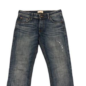 Blå jeansbyxor - Snygga blå jeans med en klassisk look och lätt slitna detaljer. Perfekta för en avslappnad stil. 