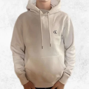 Vit hoodie från Calvin Klein - Säljer en stilren vit hoodie från Calvin Klein med CK-logga på bröstet. Den är i fint skick förutom att den är lite nopprig. Nypris 950 kr och säljer för endast 299 kr. Vid några frågor eller funderingar är det bara att höra av sig.