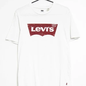 Vit t-shirt från Levi's - Vit t-shirt från Levi's med det klassiska röda logotyptrycket på bröstet. Perfekt för en avslappnad stil.
