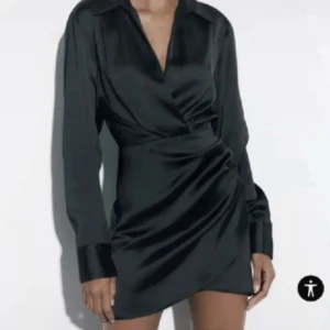 Svart omlottklänning - Elegant svart omlottklänning med långa ärmar och v-ringad, perfekt till festligaste tillfällen! Prislapp kvar!