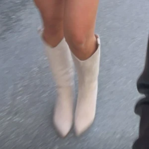 Beige cowboy boots i mocka - Snygga beige cowboy boots i mocka med spetsig tå och broderade detaljer. Köpta på bohoo. De har blivit lite missfärgade som syns på de två sista bilderna därav priset💗