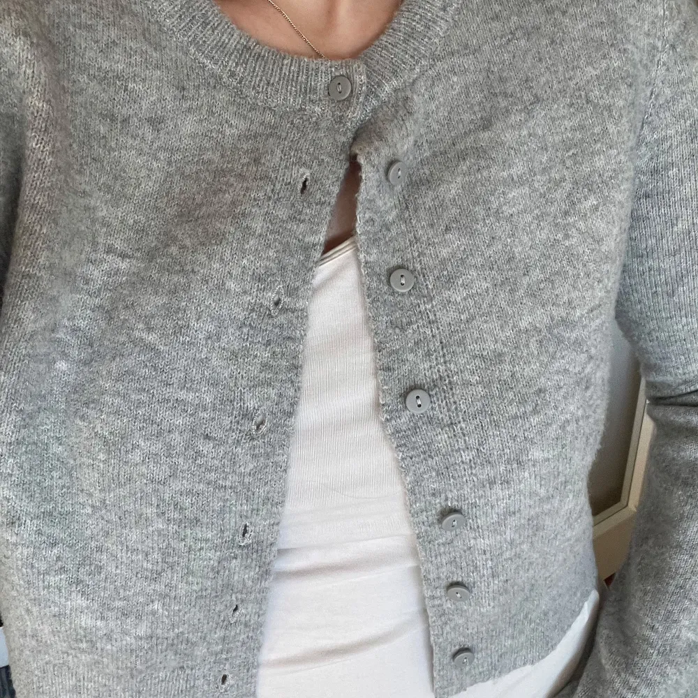 Säljer en mysig grå kofta från FB Sister Knitwear. Den är stickad med knappar framtill och har långa ärmar. Perfekt för kyligare dagar. 🩶. Neuletakit & Villapaidat.
