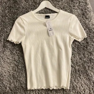 Vit ribbad topp - Söt vit ribbad topp från Gina Tricot. Nyskick med prislapp kvar🤍stl M men passar S med!
