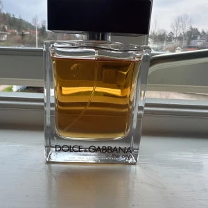 Parfym Dolce & Gabbana The One - Säljer en elegant parfym från Dolce & Gabbana, The One. Flaskan är rektangulär med en stilren design och innehåller en gyllene doftvätska. Perfekt för den som söker en sofistikerad och tidlös doft. 100Ml ungefär 5 ml använd. Original pris 1400. Pris kan diskuteras 