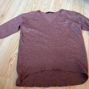 Rosa stickad tröja med v-ringning - Säljer en mysig rosa stickad tröja från lager 157. Tröjan har en v-ringad hals och långa ärmar. Perfekt för kyligare dagar med sin mjuka och bekväma passform. Passar utmärkt till både jeans och kjol. 🌸