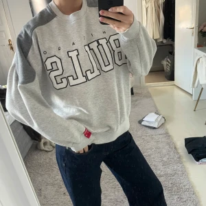 Grå sweatshirt från Pull&Bear - Säljer en super snygg grå sweatshirt från Pull&Bear med Chicago Bulls-tryck. Jätte härligt. Bra skick