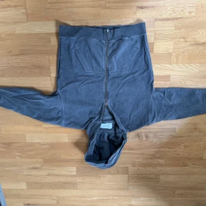 Grå hoodie från Ronning - Säljer en grå hoodie från Ronning med dragkedja och broderad detalj på ärmen. Den har en bekväm passform och är perfekt för kyligare dagar. Hoodien har en klassisk design med fickor framtill.