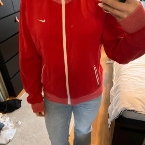 Röd vintage fleecejacka från Nike - Säljer en snygg röd vintage fleecejacka från Nike med dragkedja och vita detaljer. Jackan har långa ärmar och en liten Nike-logga. Perfekt för kyliga dagar när du vill hålla stilen. 🧥