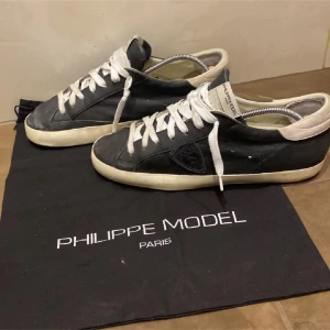 Svarta sneakers från Philippe Model - Snygga svarta sneakers från Philippe Model med vita snören och en vit sula. Skorna är i hyfsat skick🤩våga fråga om mer bilder,eller hör av er💫😍(äkta)