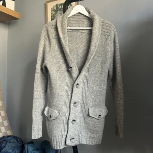Grå lamm ulls cardigan S - Säljer nu denna cardigan i lammull som är riktigt snygg och använd 1 gång. Skick 9.5/10. Super mysig att ha på sig.