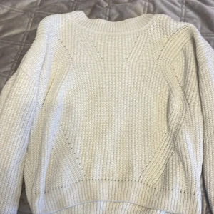 Vit stickad tröja från H&M - Säljer en stilren vit stickad tröja från H&M. Tröjan har en klassisk design med rund hals och långa ärmar. Perfekt för kyligare dagar och enkel att matcha med olika outfits. Hör av dig vid intresse! 🤍
