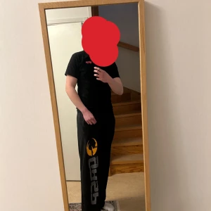 GASP byxor svarta - Säljer ett par svarta mjukisbyxor från GASP med en stor logga i grått och gult på benet. Byxorna har en elastisk midja för extra komfort. Perfekta för en avslappnad stil. Xl men passar folk som har L (dom ska vara baggy)