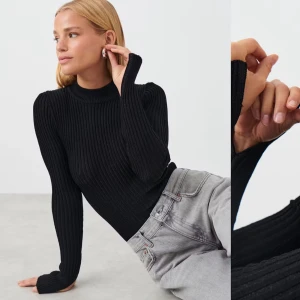 Ribbad svart tröja - Ribbad tröja med silverglitter i tyget, perfekt till nyår! När man tar bild med blixt så syns glittret väldigt väl. Det är en slits längst ner vid ärmarna också😄Använd två gånger så jättebra skick🥰 väldigt stretchigt tyg