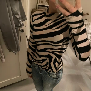 Zebramönstrad tröja från MISU - Säljer en cool zebramönstrad tröja från MISU i storlek XS. Tröjan har långa ärmar och en tight passform, perfekt för att sticka ut i mängden. 