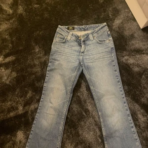 Blå jeans från Lee - Säljer ett par klassiska blå jeans från Lee. De har en bootcut passform och är tillverkade i denim med en snygg tvätt. Perfekta för en avslappnad stil.