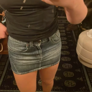 Jeanskjol med fickor - Snygg och trendig jeanskjol i kort modell med klassisk femficksdesign. Kjolen har en blå tvätt och synliga sömmar som ger en cool look. Perfekt för en avslappnad stil.