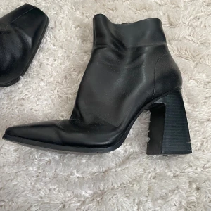Svarta boots med klack - Snygga svarta boots i skinn med en robust klack och spetsig tå. Perfekta för en stilren look.