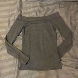 Grå offshoulder tröja - Snygg grå offshoulder tröja med långärmade ärmar. Perfekt för en stilren look. Passar bra till både jeans och kjol.