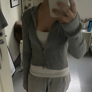 Grå ribbad hoodie från Monki - Säljer en stilren grå ribbad hoodie från Monki. Den har en dragkedja framtill och långa ärmar. Storlek S💗