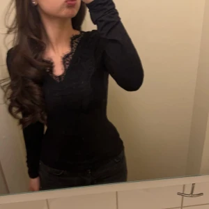 Svart långärmad topp med spetsdetaljer - Säljer min ursnygga topp med lace detaljer både fram o bak. Skims material. Har fått komplimanger varje gång jag haft den, men nu kommer den inte till användning. Den är i mycket bra skick o slutsåld online. Kontakta vid intresse, o innan köp. 🤍