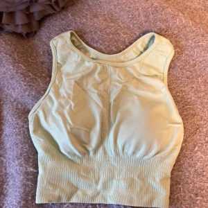 grön sporttopp - Säljer en mintgrön/grön sporttopp med ribbade detaljer. Den passar xs-s kanske m också