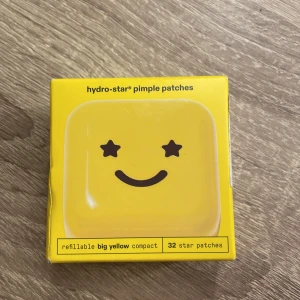 Hydro-Star Pimple Patches från Starface - Hydro-Star pimple patches är 100% hydrocolloid och hjälper till att absorbera pormaskar, minska inflammation och krympa finnar. Förpackningen innehåller 32 stjärnformade plåster i en påfyllningsbar gul ask. Perfekt för att påminna om att undvika att pilla på huden. Den är helt oöppnad och köptes för 169 kr